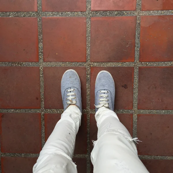 Zapatillas de deporte grises caminando por el suelo —  Fotos de Stock
