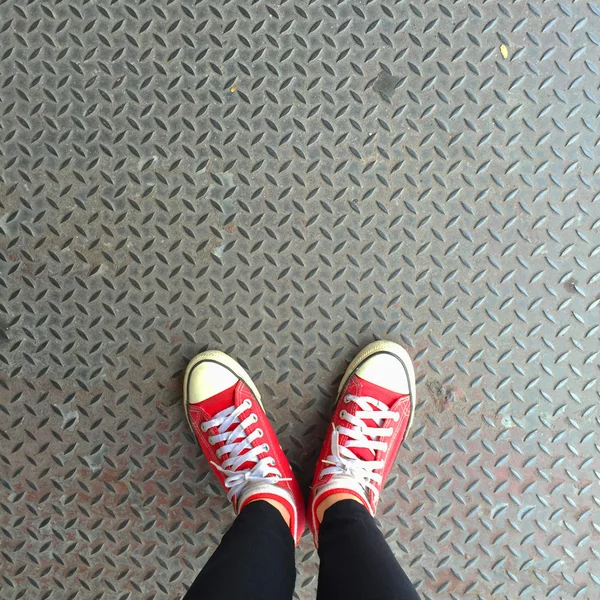 Selfie de tênis vermelhos em pernas de menina no chão — Fotografia de Stock