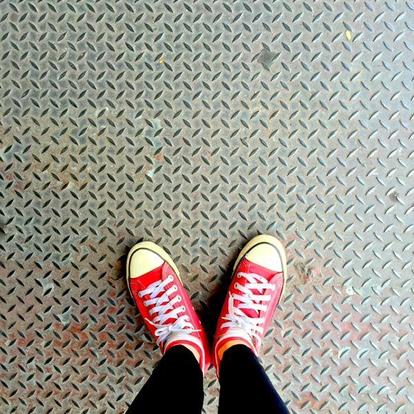 Selfie von roten Turnschuhen auf Mädchenbeinen am Boden — Stockfoto