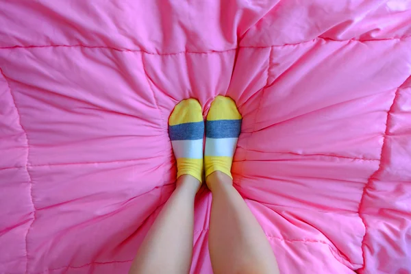 Kız ile sarı çizgili yatakta uyuyan çorap, — Stok fotoğraf