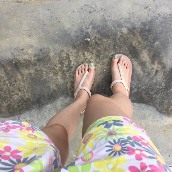 Jambes féminines portant un basculement et un pantalon court (fleur) au sol ou au sol. Vue du dessus — Photo