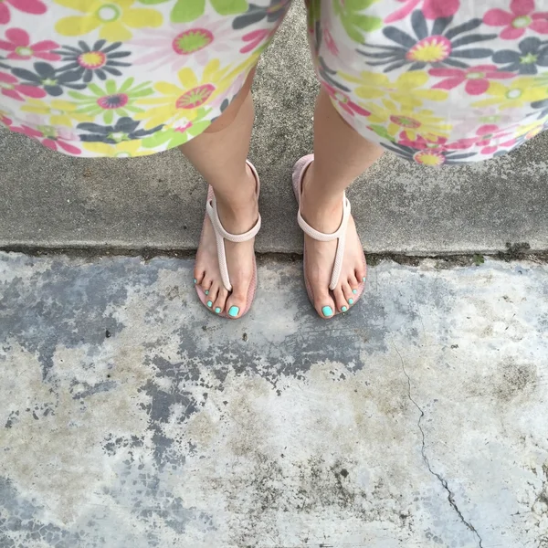 在地面或地板上穿翻翻和短裤 (花) 的女腿. — 图库照片