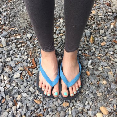 Kadın bacaklar zemin veya taş Flip flop giyiyor. Üst görünüm 