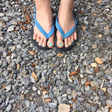 Kadın bacaklar zemin veya taş Flip flop giyiyor. Üst görünüm 