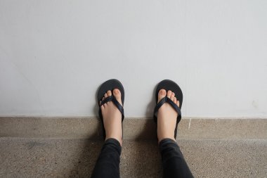 Genç kız bacaklarını açıp siyah Flipflop sandalet kat veya Grunge 