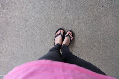 Genç kız bacaklarını açıp siyah Flipflop sandalet kat veya Grunge 