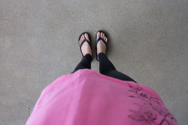 Piernas de niña en sandalias Flipflop Negro en el piso o Grunge — Foto de Stock