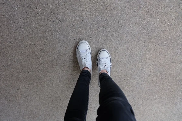 Gumshoes on Urban Grunge Background (en inglés). Imagen conceptual de las piernas con botas en la ciudad. Zapatos de pie caminando al aire libre. Joven Selphie moderno Hipster — Foto de Stock