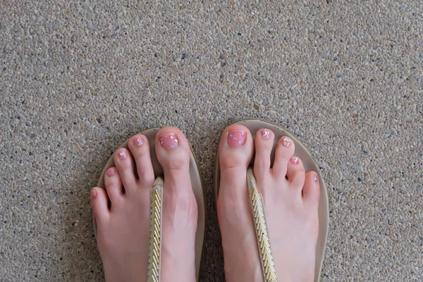 Piernas femeninas en zapatos de moda o chanclas aisladas en un fondo de tierra —  Fotos de Stock