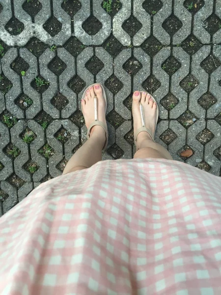 Kvinnliga ben i mode skor eller flipflop på golvet — Stockfoto