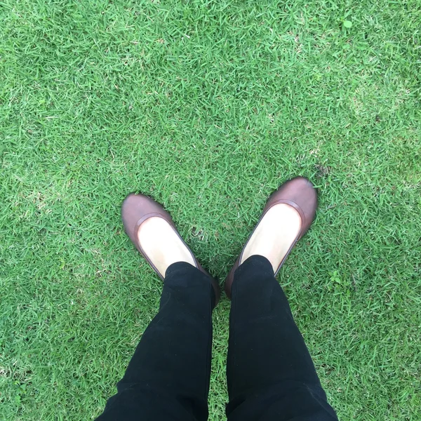 Primer plano de zapatos femeninos con estilo. Pie de pie sobre la hierba visto desde arriba —  Fotos de Stock