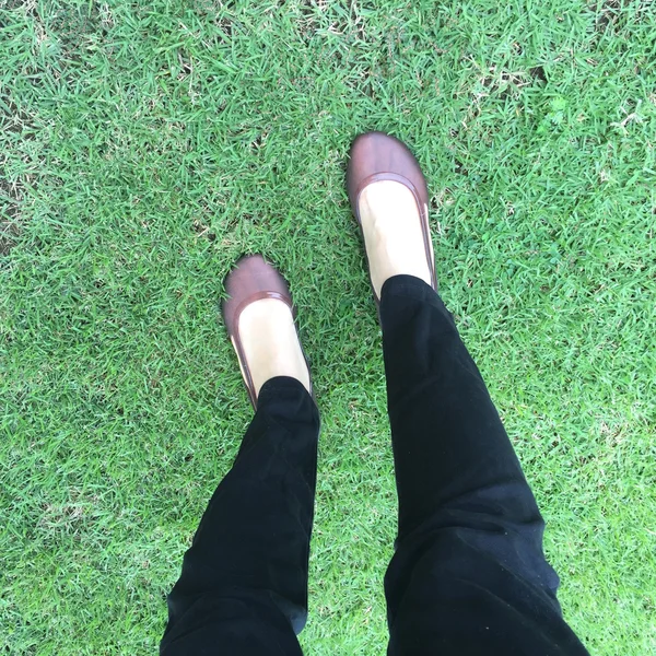 Primer plano de zapatos femeninos con estilo. Pie de pie sobre la hierba visto desde arriba — Foto de Stock