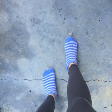 Zemin veya zemin üzerinde mavi çizgili çorap ile kız 