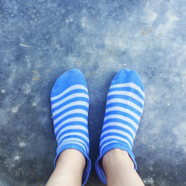 Flicka med blå randiga strumpor på marken eller golvet — Stockfoto