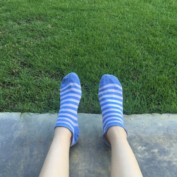 Un adolescente giace nell'erba con i suoi calzini funky in camera — Foto Stock