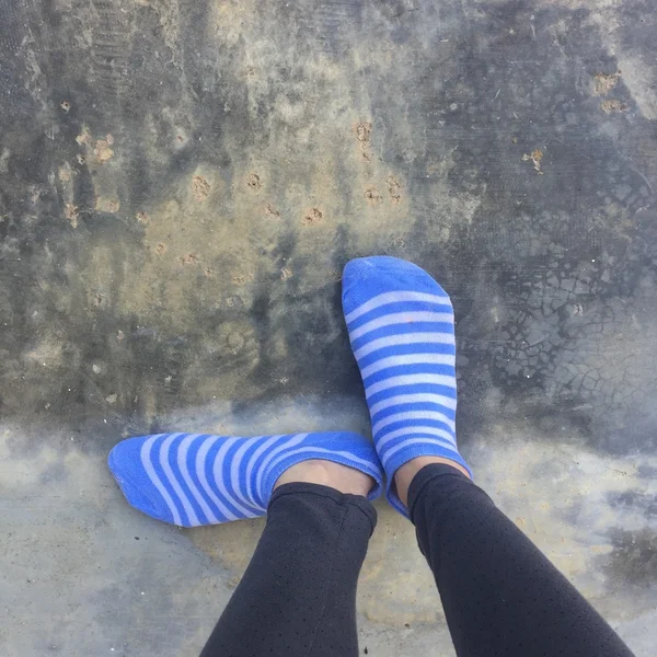 Mädchen mit blau gestreiften Socken auf Boden oder Boden — Stockfoto