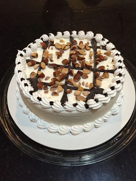Kue krim putih dengan almond di latar belakang hitam — Stok Foto