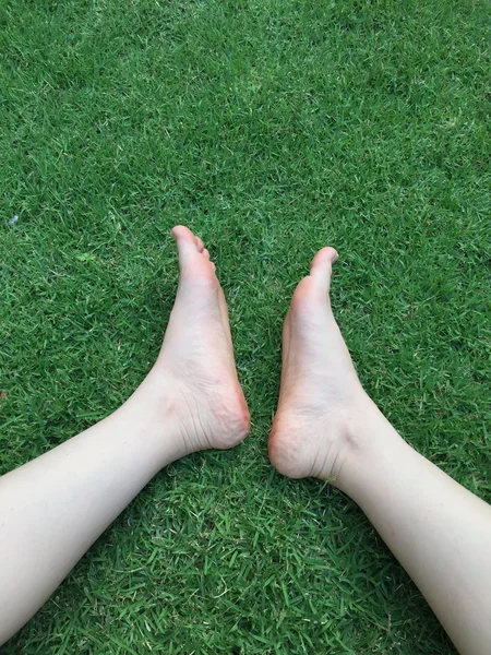Pie sobre fondo de hierba verde — Foto de Stock