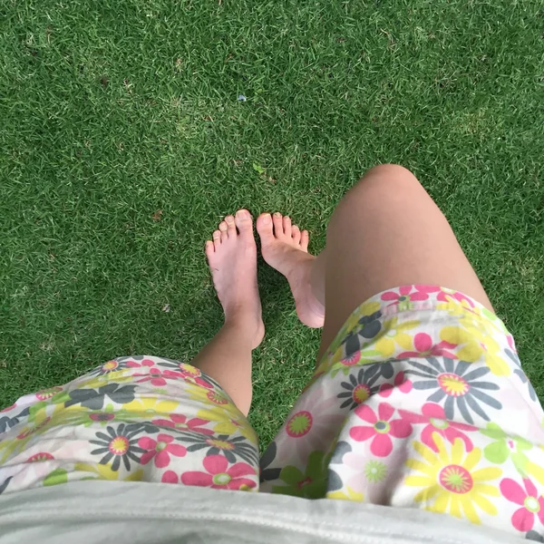 Pieds et jambes sur fond d'herbe verte — Photo