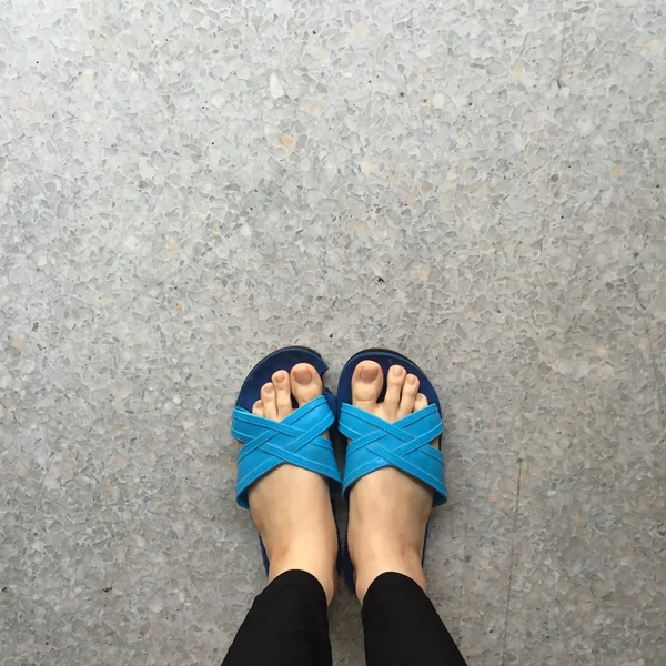 Mujer con zapatillas azules de pie en tierra o suelo — Foto de Stock