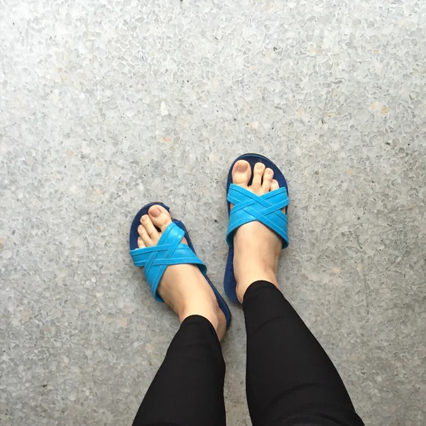 Mulher usando chinelos azul em pé no chão ou no chão — Fotografia de Stock