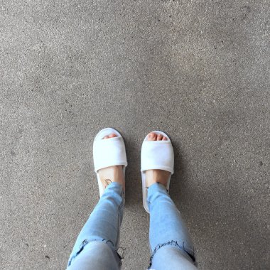 Ayakta bir kadının beyaz tüylü terlikler yakın çekim