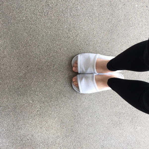 Close up de chinelos brancos de uma mulher Fluffy de pé — Fotografia de Stock
