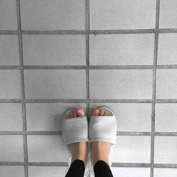 Primer plano de las zapatillas mullidas blancas de una mujer de pie —  Fotos de Stock