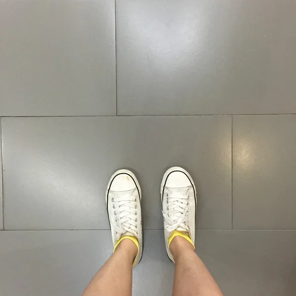 Chaussures Sneakers blanches marchant sur le sol vue du dessus — Photo