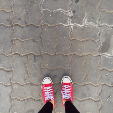 Kırmızı Sneakers Ayakkabı yürüyüş üzerinde kirli beton üst görünüm