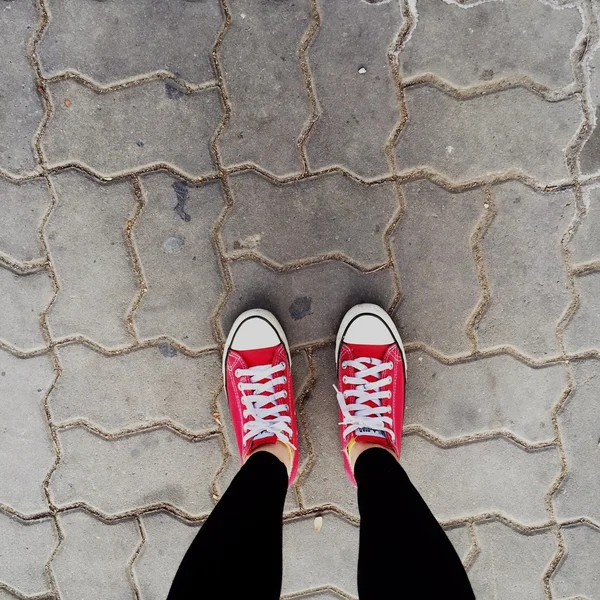 Sapatos de tênis vermelhos andando na vista superior de concreto sujo — Fotografia de Stock