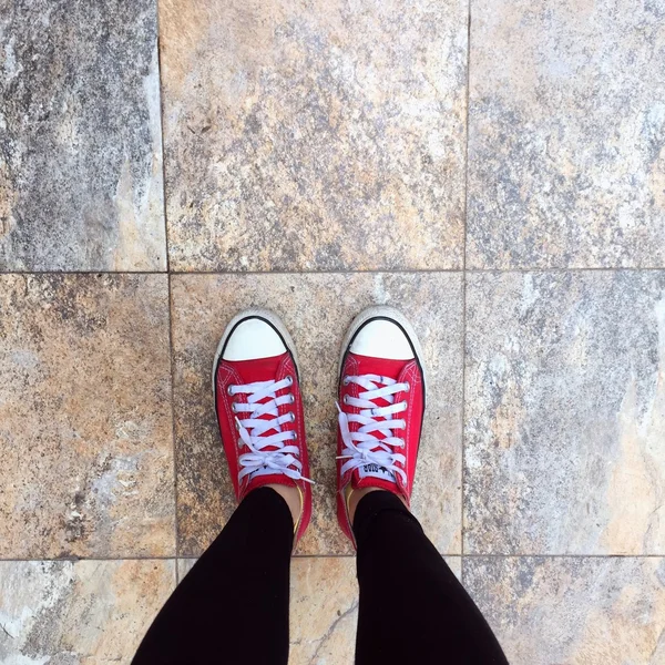 Red Sneakers Shoes Walking On Dirty Concrete Top View — Stock Photo, Image