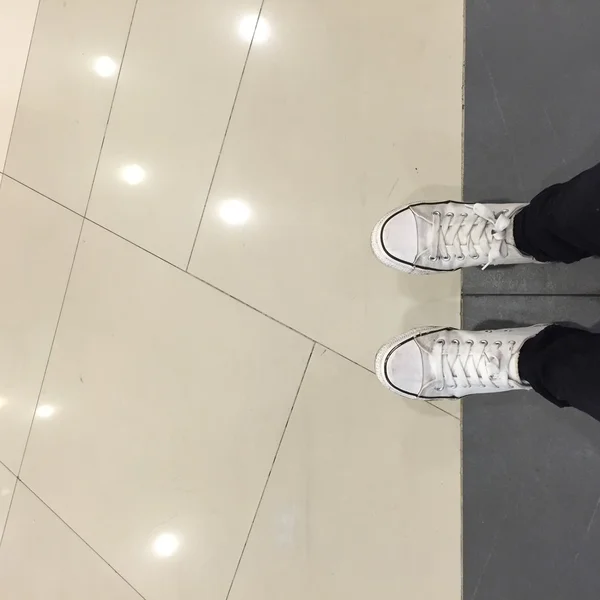 Chaussures Sneakers blanches marchant sur le sol vue du dessus — Photo
