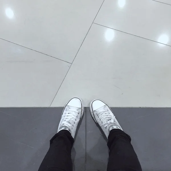 Witte Sneakers schoenen lopen op de grond boven bekijken — Stockfoto