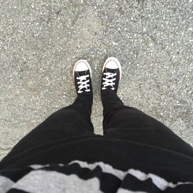 Kız ayak üzerinde siyah spor ayakkabı. Kadın siyah kot pantolon ve spor ayakkabı