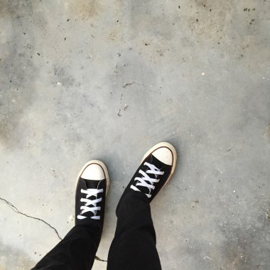 Kız ayak üzerinde siyah spor ayakkabı. Kadın siyah kot pantolon ve spor ayakkabı