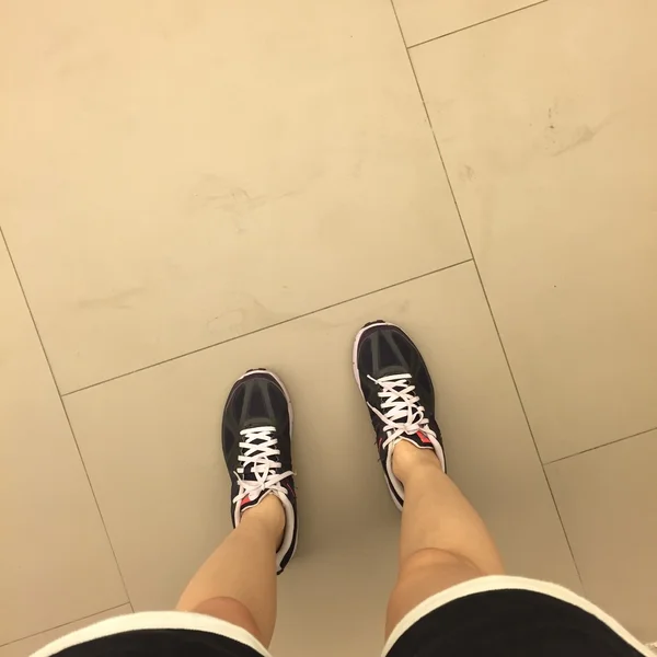 Piernas jóvenes en zapatillas — Foto de Stock