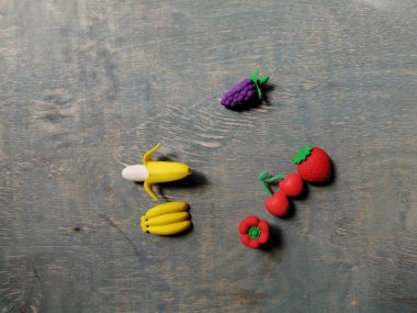 Soluk mavi ahşap arka plandaki küçük vitamin meyveleri sağlık için gereklidir.