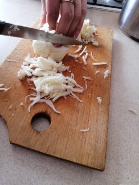 Tahtada metal bir bıçakla beyaz lahana kesme işlemi