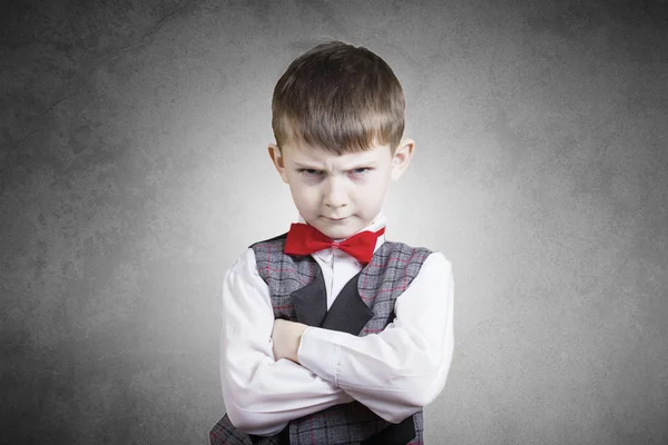 Stubborn,sad,upset  little boy,child  isolated over grey backgro