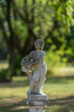 Elinde bir sepet üzümle öğleden sonra ışığında yıkanan bir çocuğun taş heykeli. Arjantin 'in kırsal bir bahçesinde zamanın ve güzelliğin sessiz bir tanığı..