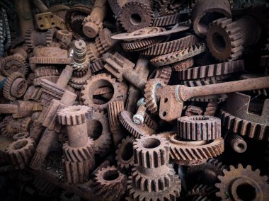 Hurdalıkta yığılmış paslı metal dişliler endüstriyel bozulmayı ve zamanın geçişini gösteriyor..
