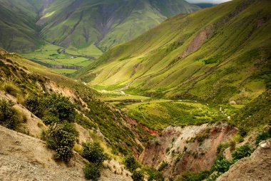Arjantin 'in Salta Eyaleti' nde yemyeşil dağlar ve derin vadiler, yumuşak yamaçlar, dağınık bitki örtüsü ve canlı And arazisini şekillendiren doğal yollar..