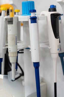 Bir stantta düzenlenmiş farklı boyutlarda ve renklerde bir dizi laboratuvar mikro pipetleri, kesin örnek işleme için hazırlar..