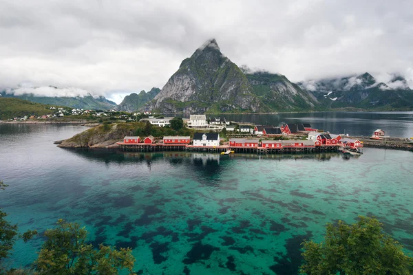 Malerischer Fjord auf den hohen Inseln mit typischen roten Fischerhütten und hohen Berggipfeln — Stockfoto