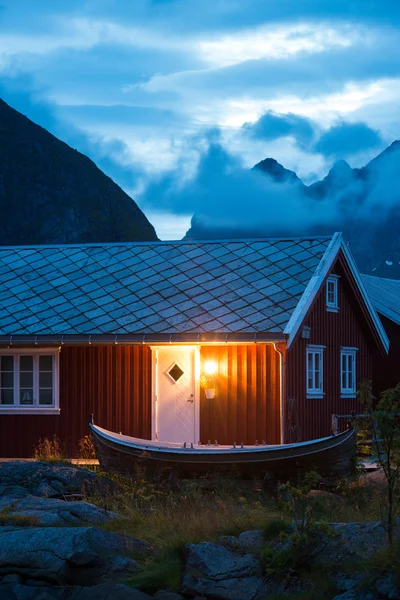 Rorbu rojo típico de Noruega con barco de pesca —  Fotos de Stock