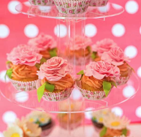 Deliciosos cupcakes com rosas creme na placa de vidro — Fotografia de Stock