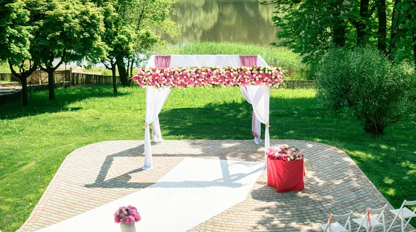 Schöner Hochzeitsbogen mit Blumen ist bereit für die Zeremonie — Stockfoto