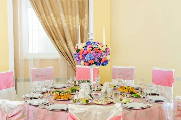 Tisch mit schönen Blumen und vielen Gerichten im Restaurant dekoriert — Stockfoto