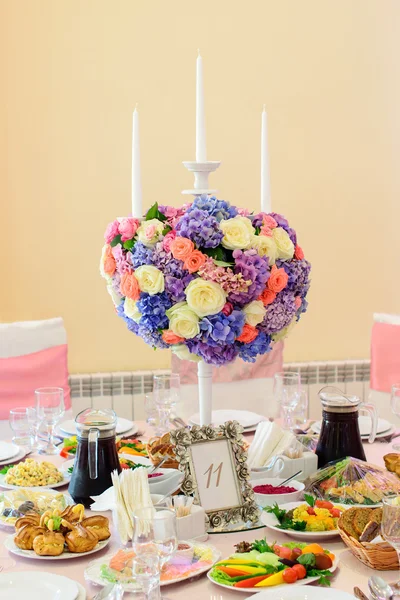 Tisch mit schönen Blumen und vielen Gerichten im Restaurant dekoriert — Stockfoto